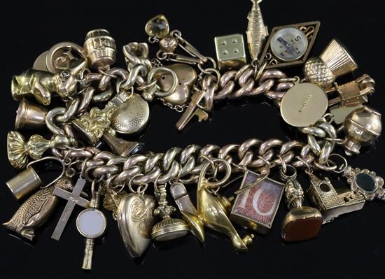 A 9ct gold charm bracelet, hung with thirty three assorted gold charms, gross 69.3 grams.